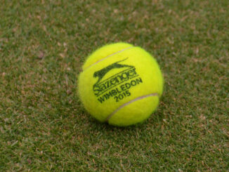 Tennisbal met Wimbledon-logo op een grasbaan, symbool voor het grasseizoen in het internationale tennis.