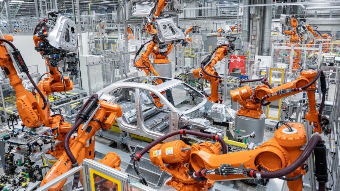 Productie Porsche Macan Leipzig 2025 Productielijn van de Porsche Macan in de fabriek in Leipzig, met industriële robots die een carrosserie assembleren.