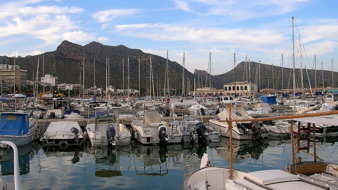 Haven van Port de Pollença op Mallorca Haven van Port de Pollença met boten en uitzicht op de bergen van Mallorca