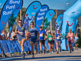 Lopers tijdens de TUI Palma Marathon Mallorca met TUI-vlaggen op de achtergrond