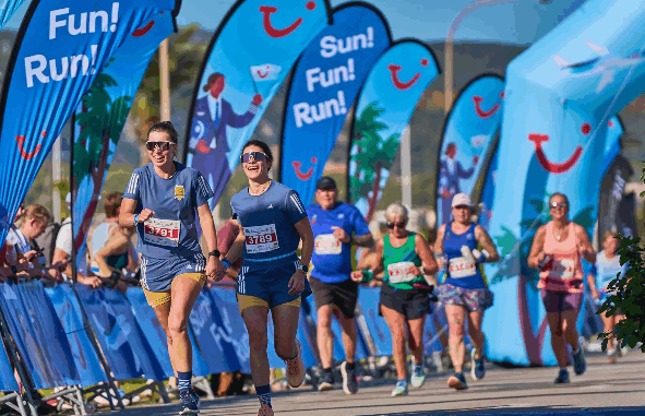 tui-palma-marathon-2025-lopers-palma-de-mallorca Lopers tijdens de TUI Palma Marathon Mallorca met TUI-vlaggen op de achtergrond