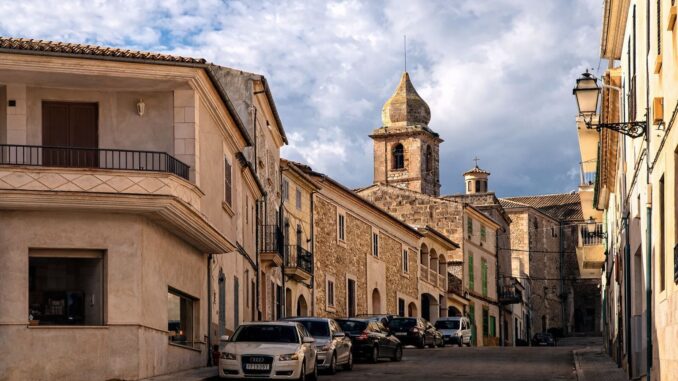 Smalle straat in Maria de la Salut op Mallorca met historische huizen en kerktoren